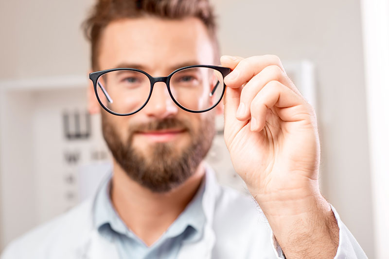 man holding up eyeglasses